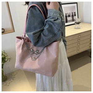 Détail du sac cabas rose avec chaîne argentée et nœud montrant texture et taille