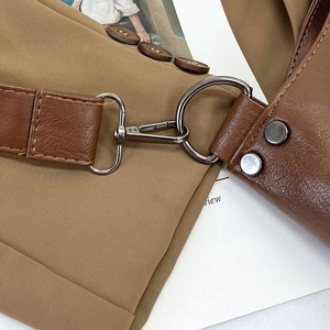 Detail of dark brown leather shoulder bag featuring gunmetal hooks and precise stitching