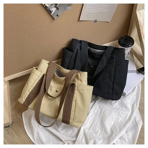Detail of canvas tote bag showing side pockets, metal buckle and durable textures