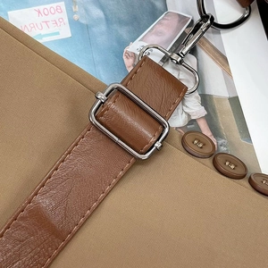 Detail of brown leather strap with silver metal adjustment buckle and rotating hook