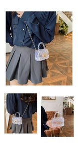Détail du mini sac gelée transparent avec matelassage, poignée perle et chaîne dorée