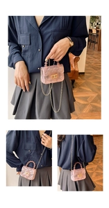 Détail du sac gelée rose transparent avec texture matelassée, poignée perle et chaîne dorée
