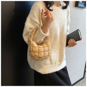 Detail of apricot quilted puffer cloud bag showing soft padded texture and top handle