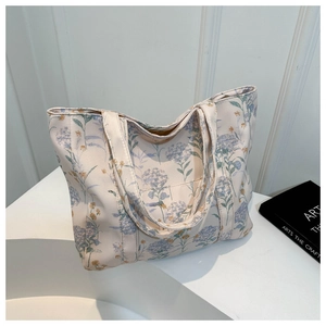 Dettaglio della grande borsa tote in tela con ortensie blu e motivi floreali gialli