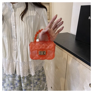 Détail du mini-sac gelée orange avec motif matelassé et poignée en perles élégante