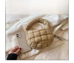 Detailed view of beige quilted cloud bag with phone for small size reference