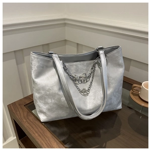 Détails du sac cabas argenté avec chaîne décorative et pendentifs papillons élégants