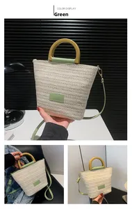 Détail du sac cabas en paille tressée avec poignées en cuir vert et bandoulière réglable