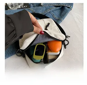 Detail view of mini nylon crossbody bag interior with sunglasses and cosmetics stored inside