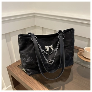 Détail du sac cabas rétro noir en toile avec chaîne argentée et pendentif papillon