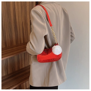 Detail of red snake pattern faux leather shoulder bag with gold chain and white pompom
