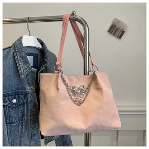 Sac fourre-tout rose avec chaîne argentée et boucle papillon suspendu au support