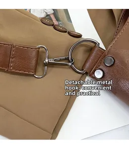 Close-up of gunmetal hook and detachable strap on dark brown pebbled leather handbag