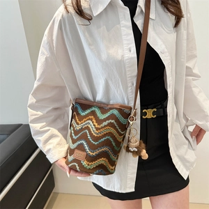 Retro striped knit bucket bag in brown with textured wavy pattern and leather details