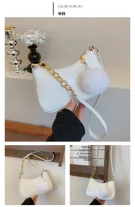 Detail of off-white faux crocodile shoulder bag with gold chain and plush charm