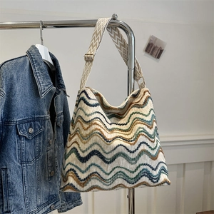 Detail of colorful zigzag weave tote bag with adjustable canvas strap and metal buckle