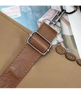 Detail of brown leather strap featuring silver metal buckle and swivel lobster clasp