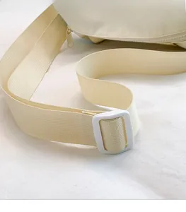 Detail of adjustable off-white woven shoulder strap with smooth plastic buckle