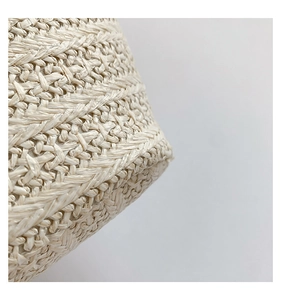 Gros plan sur la texture tissée et la courbe du fond de ce sac à main beige fait main