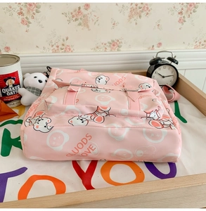 Detail shot of pink nylon backpack featuring cute cartoon bear print and front buckle pocket