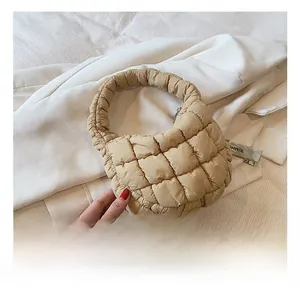 Close-up of beige quilted puffy cloud handbag featuring soft square stitch texture
