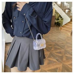 Détail du mini sac gelée transparent avec poignée en perles et chaîne dorée