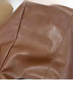 Close-up of brown litchi pattern leather fabric showing soft texture and grain