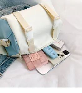 Detail view of the spacious inner compartment of the blue and beige crossbody bag