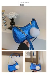 Detail of electric blue metallic snake pattern shoulder bag with gold chain and plush ball