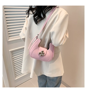 Sac demi-lune rose avec boucle fleurie argentée porté avec un blazer beige de style chic