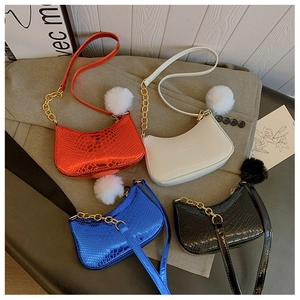 Group shot of colorful glossy snakeskin crescent bags with gold chains and fur balls
