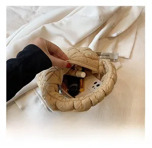 Interior view of beige quilted cloud bag showing capacity for phone and cosmetics