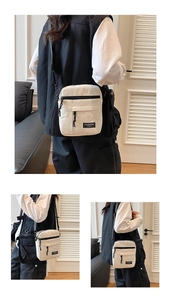 Detail view of off-white mini crossbody bag with black adjustable strap and zippers
