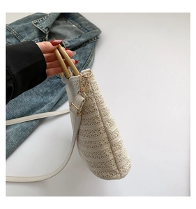Gros plan sur un sac tressé blanc avec texture ondulée et anses rondes sur denim