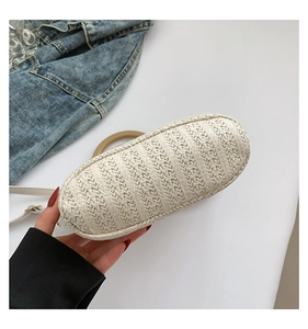 Gros plan sur la base ovale et la texture tissée soignée du sac seau en paille