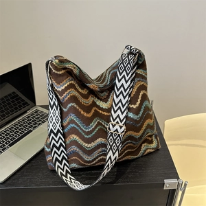 Detail of colorful zigzag woven velvet tote bag with geometric pattern wide shoulder strap