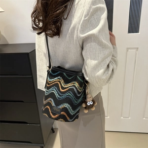Women's black bucket bag with colorful stripe embroidery and plush charm accessory