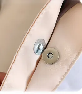 Detailed macro view of the silver magnetic snap closure on a high-quality nylon tote bag