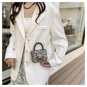 Sac gelée transparent gris chic avec texture matelassée et chaîne dorée sur mannequin