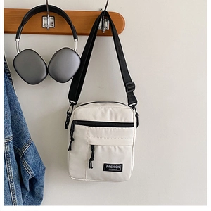 Detail showing beige nylon crossbody bag with multi-pocket design and adjustable strap