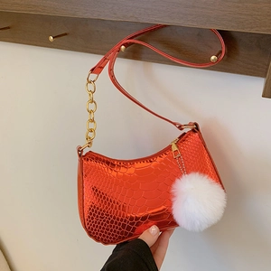 Red croc-effect glossy crescent bag with gold chain and white faux fur pom-pom