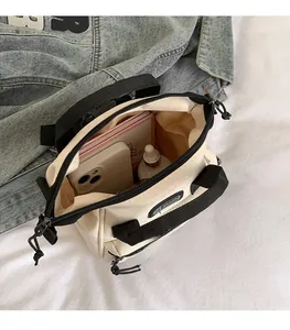 Detail van de beige canvas handtas met ruime opbergruimte voor telefoon en cosmetica