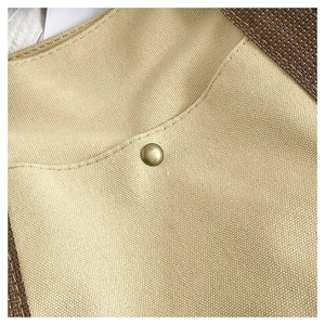 Macro detail of canvas tote bag showing heavy texture and vintage brass snap fastener