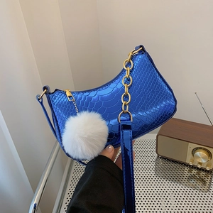 Metallic blue crocodile embossed crescent bag with gold chain and white pom pom