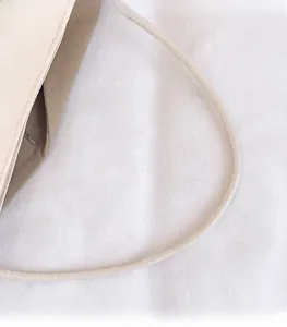 Detailed close-up of the fine stitching on the durable beige nylon tote bag handle