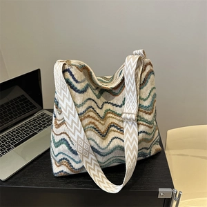 Detailed view of colorful wavy knit tote bag with wide geometric woven shoulder strap