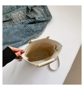 Vue de dessus du sac seau blanc en cuir avec poignée en bois et pochette zippée interne