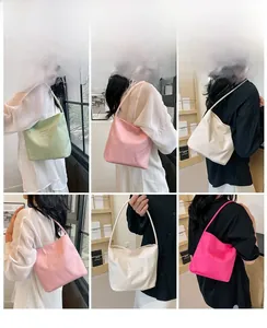 Detail showing various colors of nylon tote bags with fine embroidery on shoulder straps