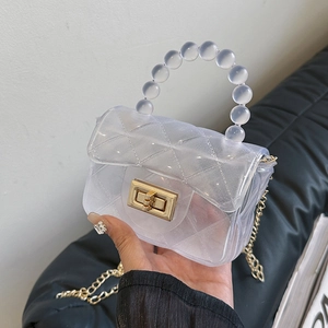 Détail du mini sac gelée avec poignée en perles, motif matelassé et chaîne dorée fine