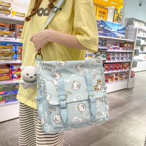 Minimalist light blue canvas crossbody bag with cartoon bear print and plush pendant accessory